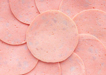 Sliced ham ​​bologna sausage stacked in a circle. Top view