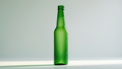 Close-up of a transparent green beer bottle with a long neck, cold and condensation-covered, on white background.