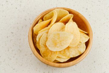 Potato Chips, served in wooden bowl on white background.
