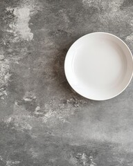 Clean white plate on gray textured surface overhead shot minimalist food photography studio setting
