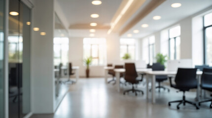 Blurred background of spacious minimalist coworking office featuring sleek white desks, black chairs, and abundant natural light, creating a productive and inspiring work environment.