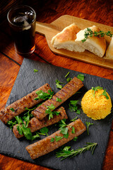 Tender grilled kebabs garnished with herbs, accompanied by fluffy rice and warm bread