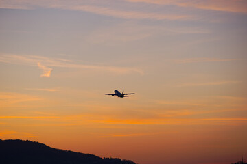 Passenger airplane ascending at Swiss Airport Zürich Kloten on a spring sunset with colorful sky background. Photo taken April 8th, 2025, Zurich Kloten, Switzerland.