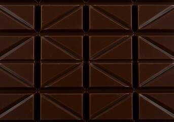 Close-up of a dark chocolate bar with a geometric pattern of squares and triangles for a sweet treat