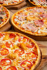 Vibrantly topped, colorful pizzas are artfully arranged on wooden boards, tempting indulgence