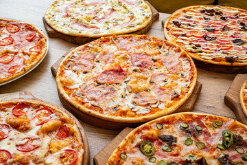 A variety of delicious pizzas with diverse toppings served on wooden boards