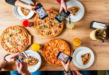 Friends savor tasty pizzas and capture memories at a vibrant gathering over shared joy