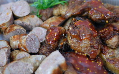 Grilled assorted meat platter with potato wedges and sauces