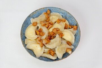 gray dumplings with cabbage and bacon on a white plate home cook hold a plate with a national Slovak dish - Bryndzove Pirohy.
