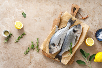 Fresh raw sea bream fish or dorado fish with lemon and herbs, top view