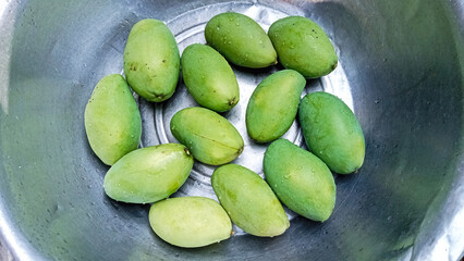 Shiny Green Mangoes in Polished Metal Bowl