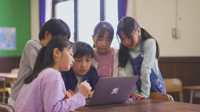 パソコンを囲む小学生