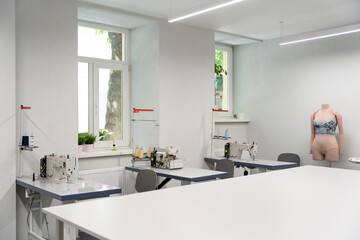 Dress designer studio with sewing equipment and table in the middle