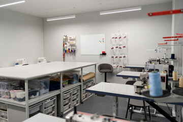 Dress designer studio with sewing equipment and table in the middle