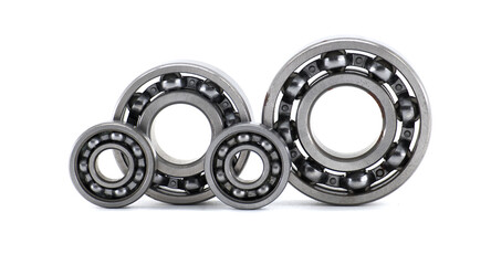 Four metallic ball bearings standing isolated on white background