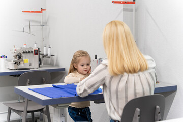 Cute little girl spending time with her mom in a designers studio