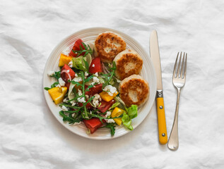 Potato tuna patties and fresh vegetable salad on a light background, top view. Delicious lunch, dinner, brunch