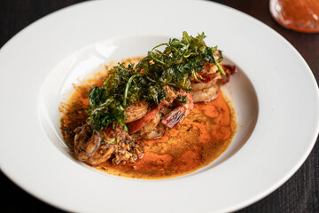 Cooked shrimp in a bowl with broth and fried garnish