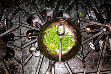 Overhead of peas in a skillet on burner