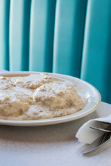 Close up of biscuits and gravy against blue backdrop vertical