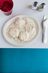 Overhead of biscuits and gravy in booth at diner vertical