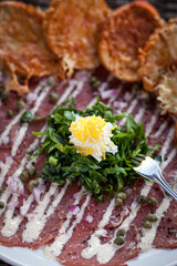 Carpaccio dish with garnish and capers vertical