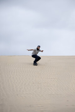 Sandboarder cruising down dune. Ca&ntilde;oncillo, Per&uacute;.