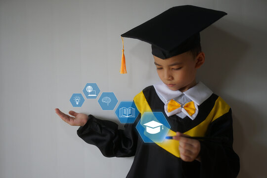Portrait of a small boy dressed in a graduation cap and gown, against a simple backdrop with copy space. For child education and graduation contents. 
