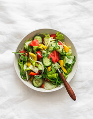 Fresh vegetable salad with seasonal vegetables on a light background, top view