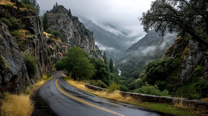 Fototapeta premium Mountain road winding through misty valley