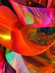 Holographic plastic sheets bending in vibrant rainbow tones, abstract background