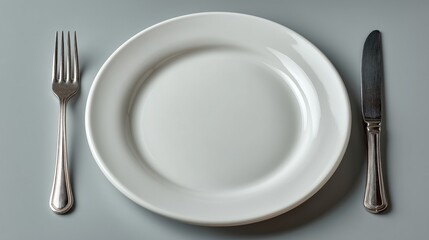 Minimal composition with an empty white plate and cutlery symbolizing dietary restrictions, fasting and aesthetic fat reduction practices including lipolytic injection therapy