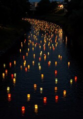 River glows with lanterns floating on the water during a festival night
