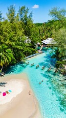 Explore the crystal-clear waters and soft sandy beaches of Koh Kood, Thailand. Visitors relax amid lush surroundings, enhancing the tranquil atmosphere perfect for a peaceful getaway.