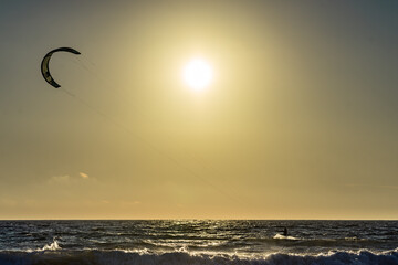 Kite surfer riding waves. Kiteboarding sport.