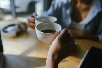 Two friends clink coffee mugs in a cozy café, sharing a relaxed morning moment filled with warmth, conversation, and connection