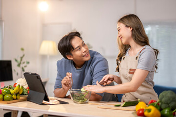 The man is holding a fork and the woman is touching his hand