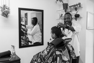 Barber cutting young boys hair