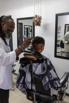 Barber shaving a young mixed race boys hair