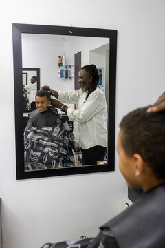 Barber shaving a young boys hair