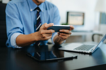 Businessman using smartphone and working on laptop computer  Woman freelancer online working in office