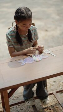 Asian girl making handmade necklace accessories