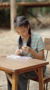 Asian girl making handmade necklace accessories