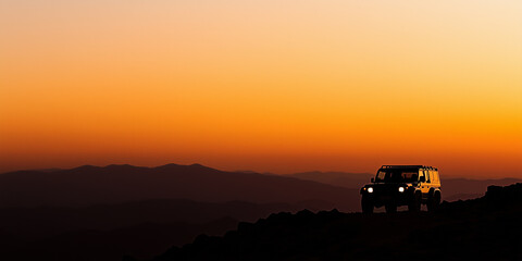 Off-Road Vehicle Silhouette At Sunset Over Stunning Mountain Landscape