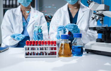 Scientists conducting research in a biotechnology lab, using pipettes and test tubes for medical...