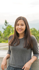 A vertical picture of a young Asian woman traveling.