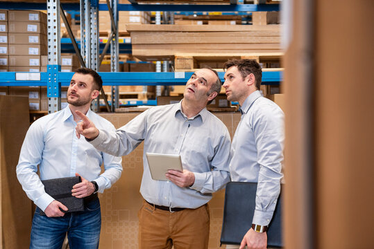 Employees having a meeting in a warehouse setting