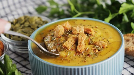 Creamy vegetable soup with spices and rusks, chef tastes soup with a spoon. High quality 4k footage - Powered by Adobe