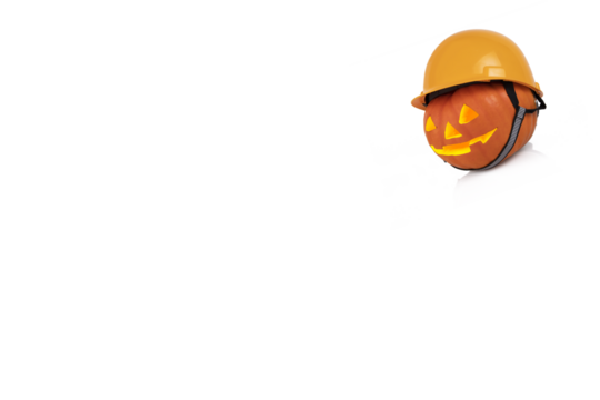 Orange pumpkin with glowing eyes in yellow construction helmet. Safety concept. Transparent background. Copy space