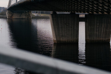 A striking perspective of a cable-stayed bridge over a calm river, showcasing urban infrastructure and architectural design